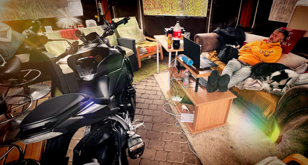 Rag sleeping outside in the patio with feet up on the table next to his parked up Suzuki GSX.