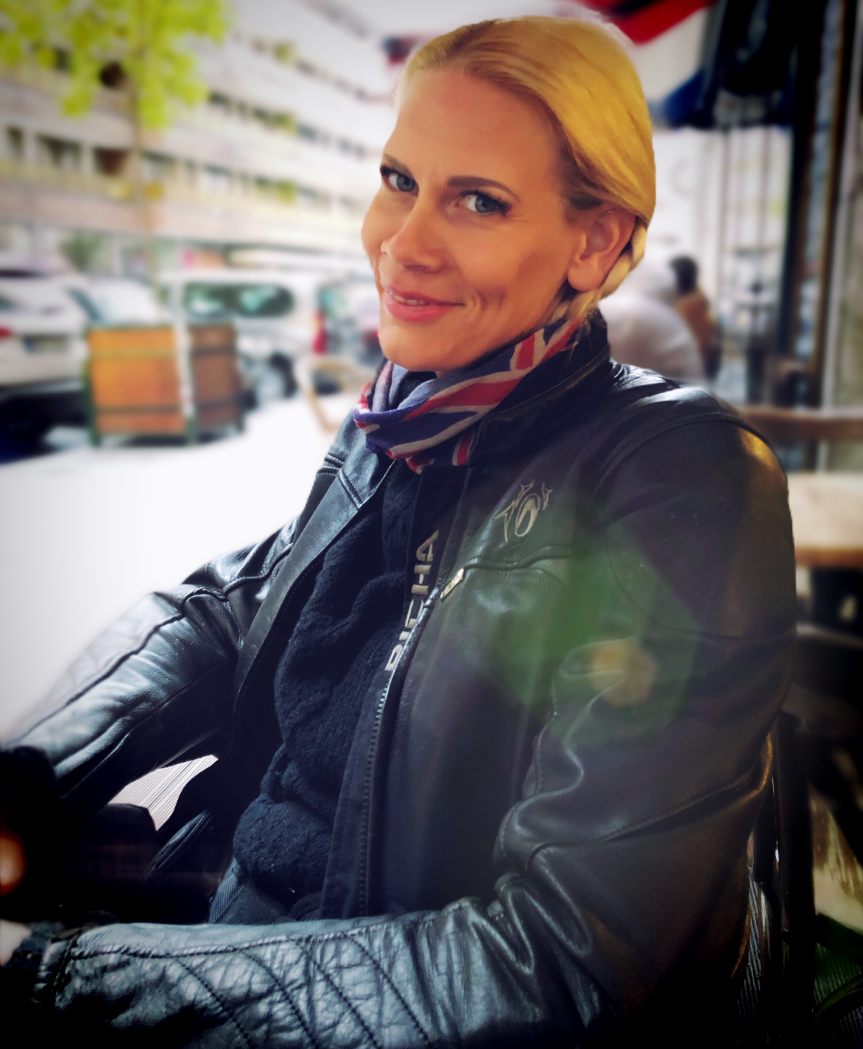 Sophies wearing her leather jacket and neck scarf with two side bread in her hair downtown Budapest.