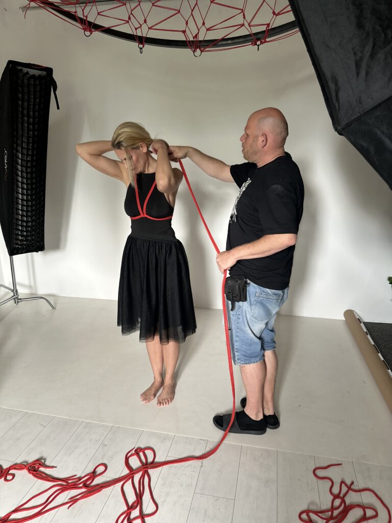 SophieS being tied up by Krisztián Seiner photographer in preparation for a shoot where she gets suspended.