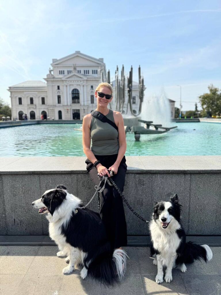 Sophie posing in Severin holding the dogs in front of a fountain at the main square.