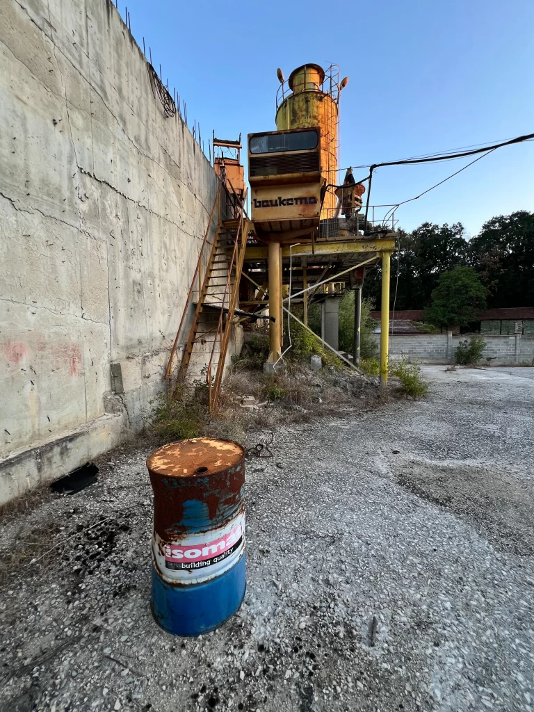 An industrial estate showing left out machinery and an old barrel.