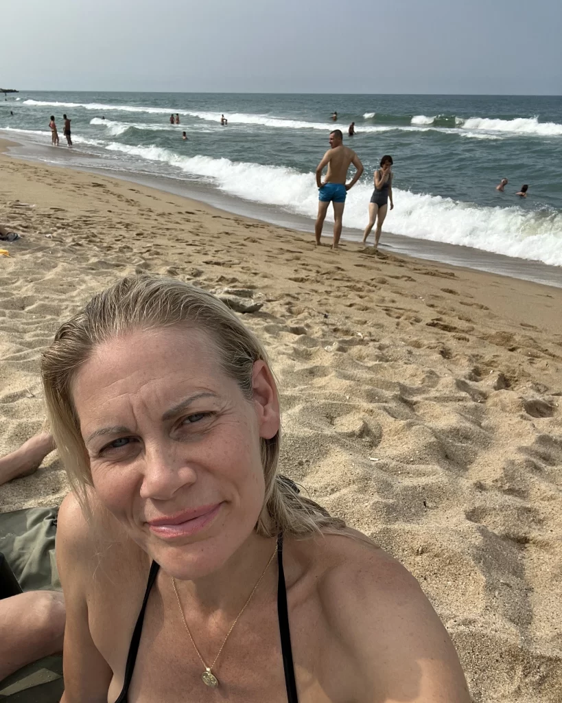 Sophie is sitting in the beach at Varna in a bikini with the sea in the background,