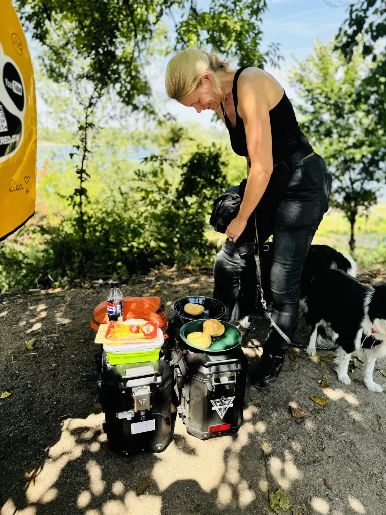 Zsofi prepares some lunch using the bike panniers as a kitchen bench in a lay-by in Bulgaria