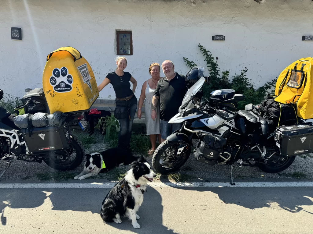 SophieS posing with the owners of Serendipity in Bulgaria, the two fully loaded bike and the dogs.