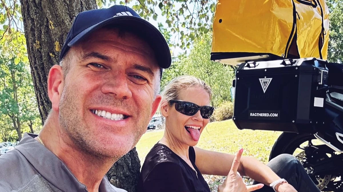 Rag and SophieS sitting under a tree next to their bikes with the Pooch carrier on the motorbike.