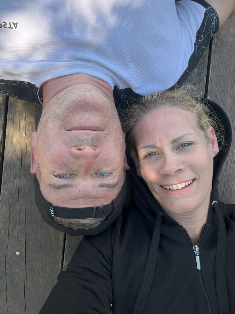 Zsófi és Ken egymás felé fordulva egy patak partján.