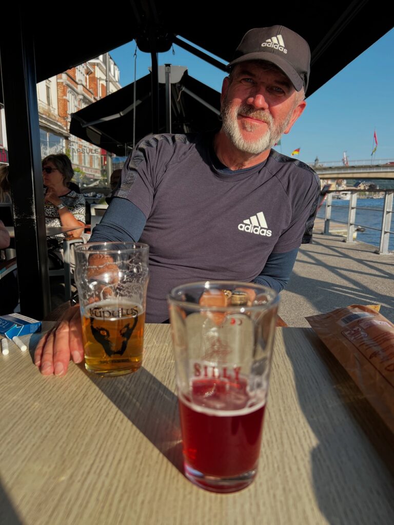 Ken éppen belga sört iszogat a folyóparti kocsma teraszán.